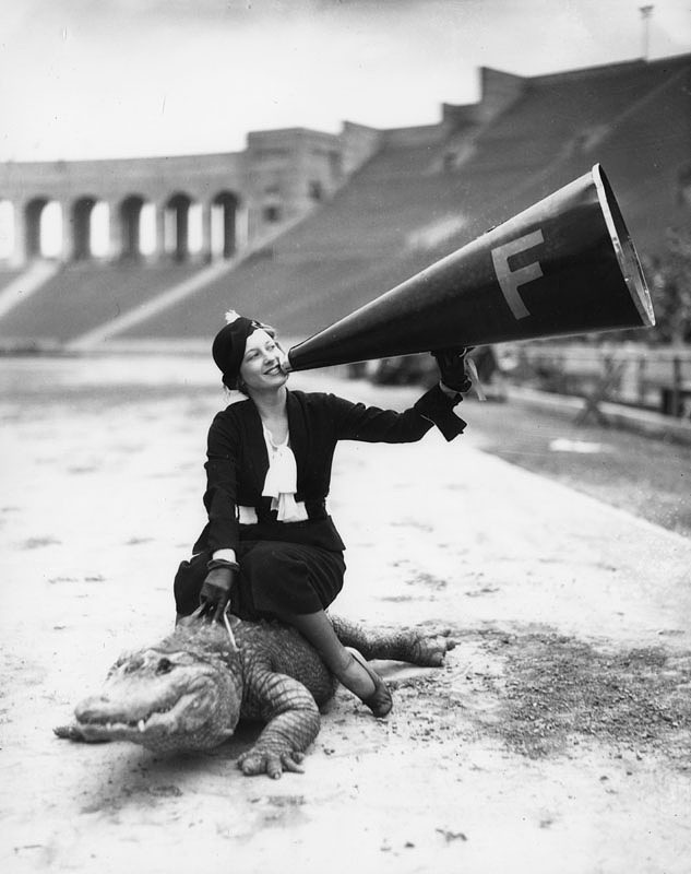 A woman riding an alligator in the Los Angeles Memorial Coliseum.  The alligator is evidently the team mascot, c 1930s (via Los Angeles Public Library).jpg